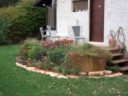 צמחי כיסויי וצמחים נשפכים להסתרה שתולים במיכלי פלסטיק המוצבים על גבי בלוקים ומוסתרים ע"י טרסות עץ